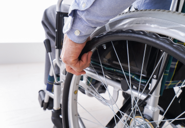 Person's hand on a wheelchair wheel